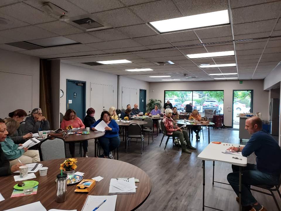 Image shows workshop attendees and Johnny Sage in the fellowship hall.