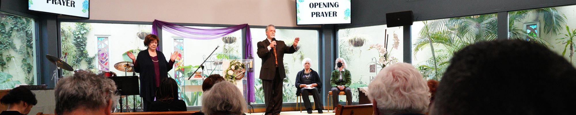Image shows Rev. Greg Dorst with several others at the front of the sanctuary.